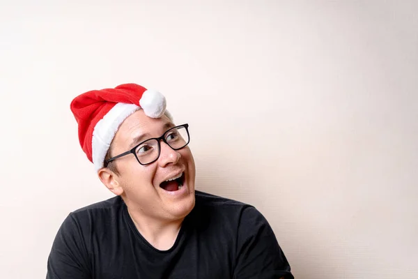 Jonge grappige man met kerstmuts op witte achtergrond. Droevige kerstman. Kerstmis — Stockfoto