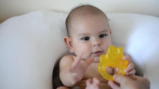 Joli bébé avec une bague de dentition jaune. Mignon portrait de bébé — Video