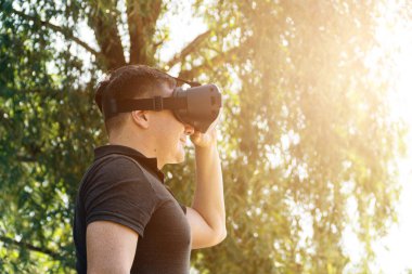 Gülümse mutlu adam, yaz mevsiminde sanal gerçekliğin video kulaklığını kullanarak tecrübe kazan.