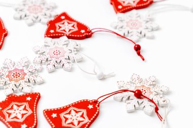 Noel ağacı süslemeleri kırmızı ve beyaz kar taneleri ve süslemeli çanlar. Arkaplan kışı