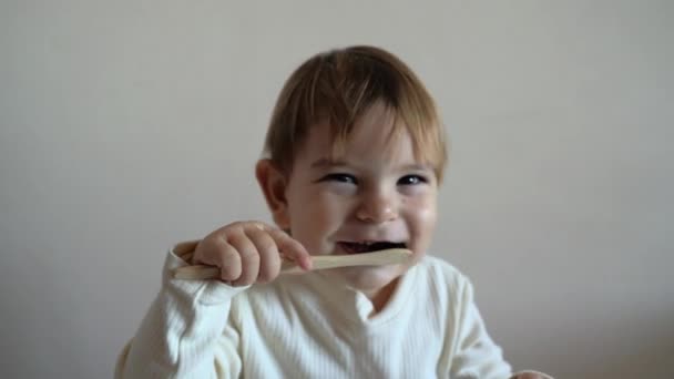La niña se cepilla los dientes con un cepillo de dientes de bambú. concepto de cero residuos — Vídeo de stock