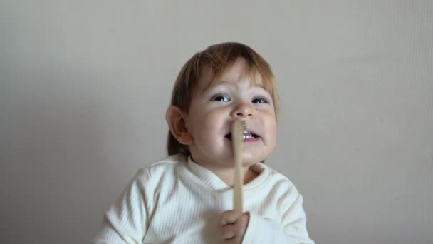 Çocuk kız dişlerini bambu bir diş fırçasıyla fırçalıyor. sıfır atık kavramı — Stok video