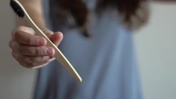 Close-up na mão da mulher está mostrando bambu escova de dentes.Zero resíduos, banheiro, plástico livre — Vídeo de Stock