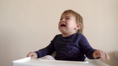 Yüksek sesle bebek bebek sandalyesinde çığlık atıyor. Açlık, diş çıkarma ya da erime kavramı. Portre