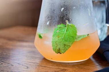 Naneli cam kavanozda portakal suyu limonatası. Lokantada yaz temizliği. Açık havada.