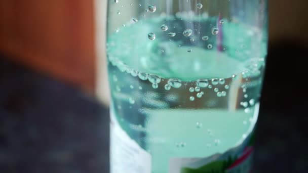 Primo piano della bottiglia riempita con acqua gassosa o coda. acqua blu — Video Stock