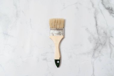 Mermer zemin üzerinde boya aracı fırça üst görünümü. Asgari yenileme veya el işi kavramı