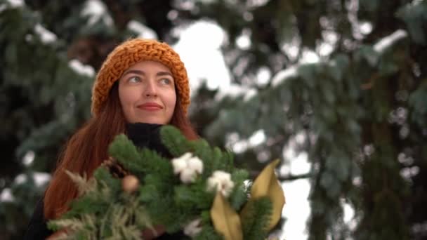 Όμορφη καυκάσιος κορίτσι και στεφάνι Χριστουγέννων σε εξωτερικούς χώρους o na χιονισμένη ημέρα — Αρχείο Βίντεο