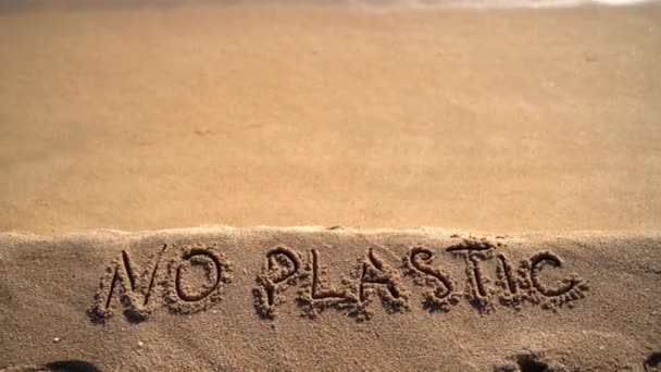 Nenhum texto plástico escrito à mão no fundo da praia de areia. Problema de poluição marinha — Vídeo de Stock