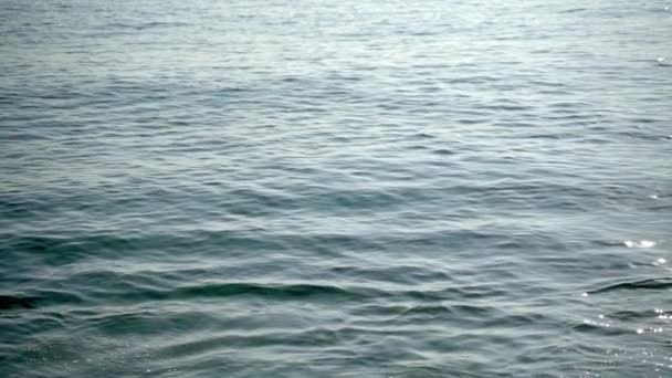 Primer plano de la tranquila superficie del agua del océano azul. En cámara lenta. Viaje de verano — Vídeos de Stock