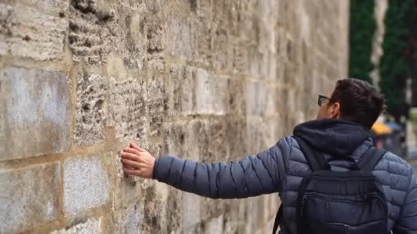 Homme surface coup de main, glissière sur le mur pierreux de vieux bâtiment au quartier gothique de Barcelone, Voyage — Video