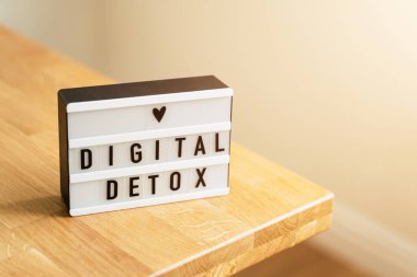 Dijital detoks günü. Ahşap arka planda ışık kutusu ve beyaz duvarlar. Gadget yasağı