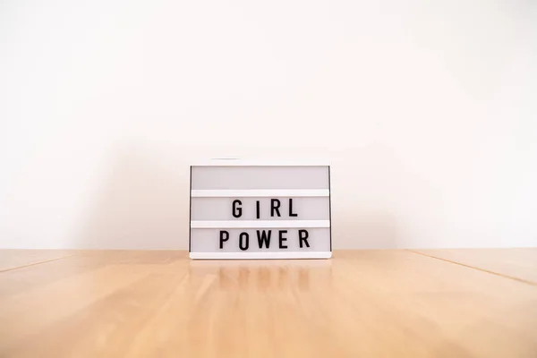 Texto de poder de la chica en la caja de luz. Vista lateral sobre mesa de madera. Igualdad de género — Foto de Stock
