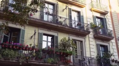 Bitkilerle dolu balkonlu Barselona eski evi cephesi. Şehir ormanları. Ekolojik yaşam