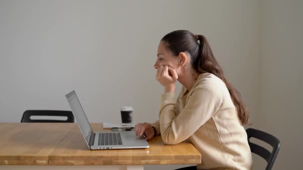 Junge Frau, die zu Hause arbeitet und mit den sozialen Medien zögert. Homeoffice-Outfit — Stockvideo