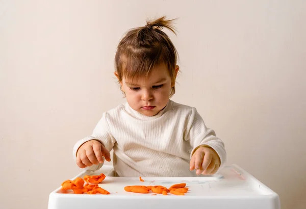 Ett litet barn leker med stålar. Modellerar orange sol. Kreativitet fantasi — Stockfoto