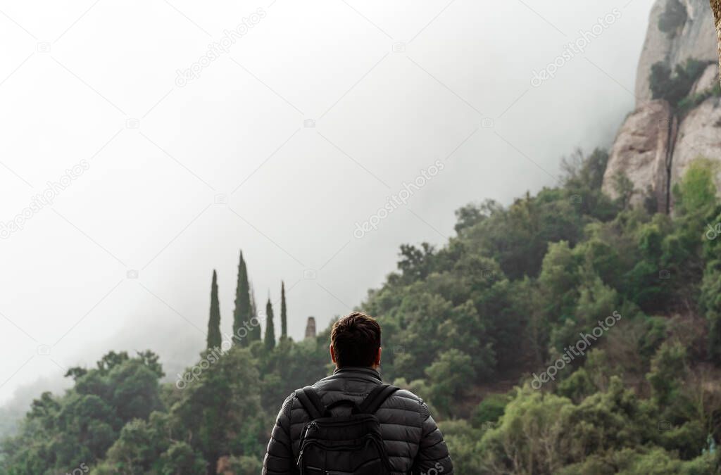 Back view of man on hiking trail. Backpacker traveling. 