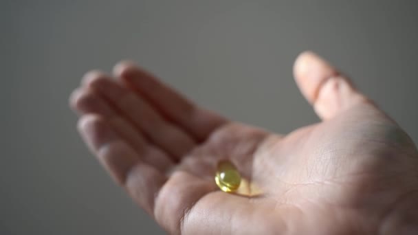 Un puñado de píldoras omega, grasas saludables, vitamina E — Vídeo de stock