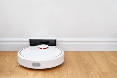 Smart home concept. Charging automatic robot vacuum cleaner 