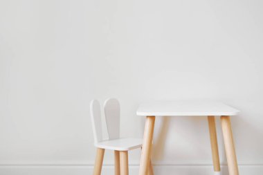 Stylish child table and chair. White and wooden colors. Scandi style