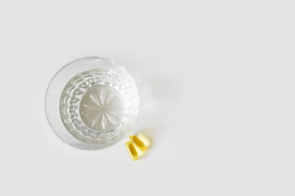 Glass of water and omega 3 capsules on white table. Natural medications concept — Φωτογραφία Αρχείου