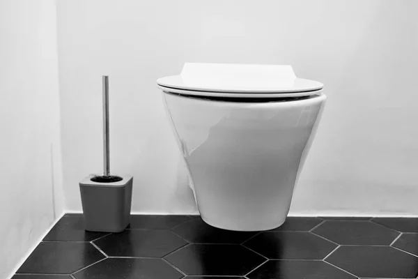 Suspended toilet in wc with black tiles on the floor — Φωτογραφία Αρχείου