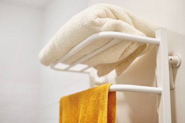Electric towel rail for drying wet towels. White pipes.