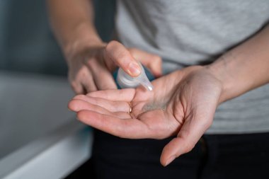 Kadın evde ellerini antibakteriyel sabunla yıkıyor.