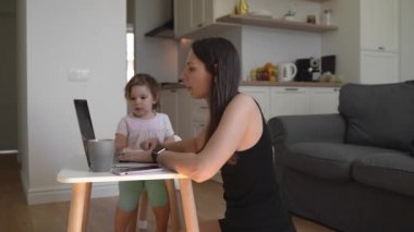 Anne, bebek bebekle evde çalışıyor. Ağlayan çocuk ve stresli kadın. Evde kal.