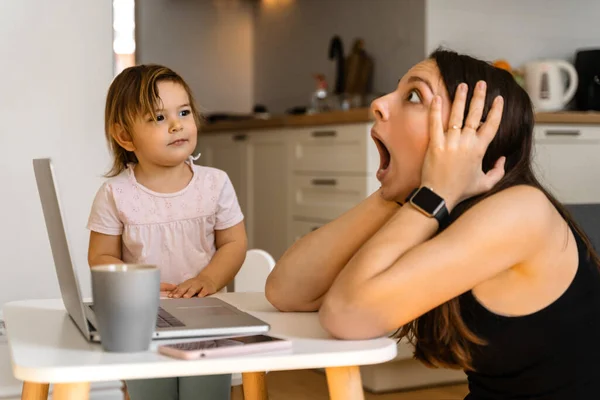 Stressed young woman working from home with small child. Home office of single mother — Stock Photo, Image