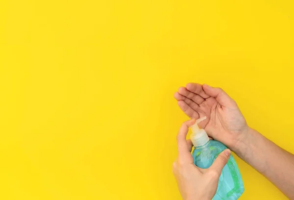 Πλύσιμο χεριών με μπλε υγρό σαπούνι ή απολυμαντικό. Κάτοψη σε κίτρινο φόντο — Φωτογραφία Αρχείου