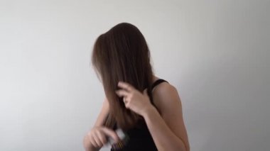 Kafkasyalı genç bir kadının sabah rutini. Saçlarını tarıyor.