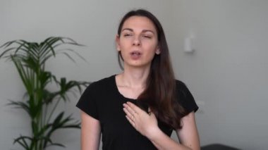 Genç bir kadın dirseğine doğru şekilde öksürüyor. Grip ya da grip belirtileri. Covid-19 salgını