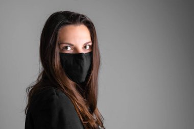 Siyah koruyucu maske takan genç bir kadın. Grip ya da virüs salgını. Alerji sezonu