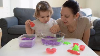 Kinetik kum oynayan çocuklu genç bir anne. Birlikte iyi vakit geçirin. Yaratıcılık gelişimi