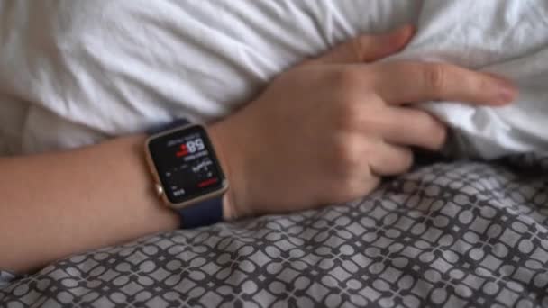 Kéz okos órával az ágyon. Az alvási szokások és a pulzus ellenőrzése. — Stock videók