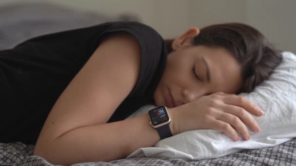Hand mit intelligenter Uhr auf dem Bett. Überwachung von Schlafmustern und Puls. — Stockvideo