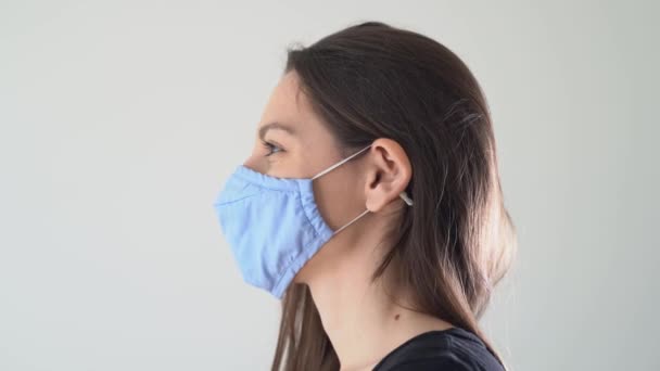 Junge Frau zieht Gesichtsmaske ab. Das Ende der Operation, Quarantäne, Epidemie. Glückliches Lächeln — Stockvideo