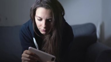 Genç bir kadın gece akıllı telefonuyla video oyunu oynuyor. Dijital bağımlılık. Sanal yaşam