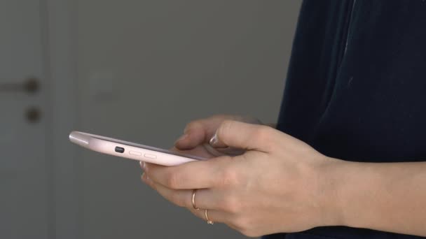 Detailní záběr rukou mladé ženy s chytrým telefonem doma. Textování, chatování, nakupování, práce online koncept. — Stock video