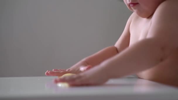 Enfant en bas âge joue avec la boue collante jaune. Activité à domicile pour les tout-petits à la maison. Développement des compétences motrices — Video