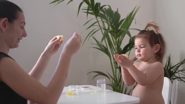 Ragazza e madre del bambino stanno giocando con la melma appiccicosa gialla. Attività a casa bambini a casa. Sviluppo delle competenze motorie — Video Stock