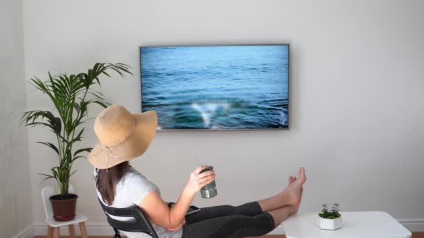 Mujer en casa fingiendo estar en la playa. Pantalla de TV. 2020 viaje cuarentena de verano. Quédate en casa. — Vídeos de Stock