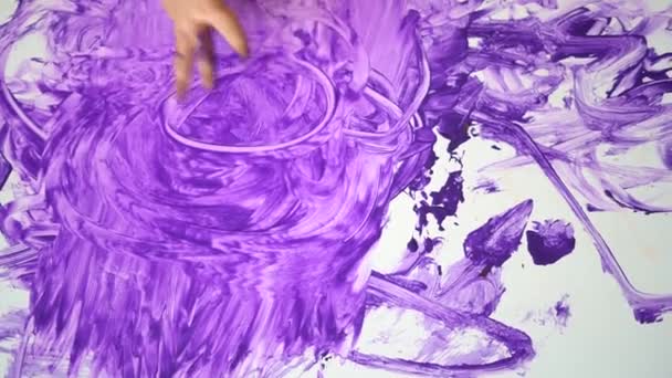 Közelkép tetejére kilátás csecsemő kezét, hogy rendetlenség lila festék az asztalon. — Stock videók