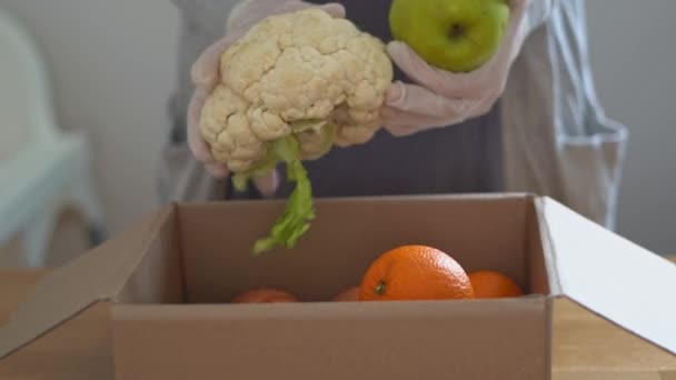 Eldivenli kadın ellerini taze meyve ve sebzelerle kapatın. Çevrimiçi süpermarket — Stok video