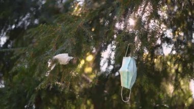 Dışarıdaki ağaçta tıbbi maske. Covid-19 karantinasından kaynaklanan kirlilik
