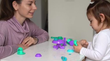 Çocuğuyla evde hamur oynayan genç bir anne. Bebekle ev aktivitesi. Aile zamanı.