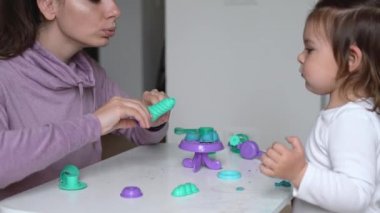 Çocuğuyla evde hamur oynayan genç bir anne. Bebekle ev aktivitesi. Aile zamanı.