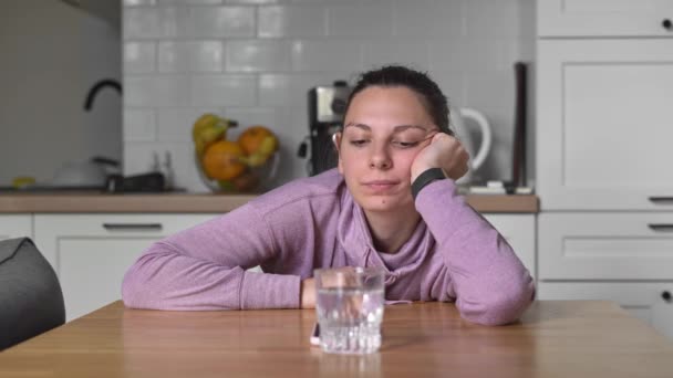 Wanita muda di rumah minum air dan ingin makan. Konsep puasa berselang-seling. menunggu untuk makan jendela — Stok Video