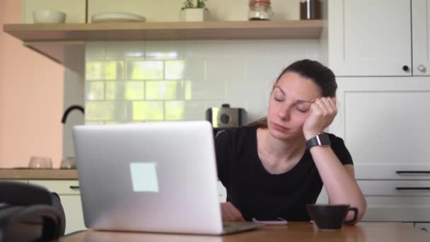 Een jonge vrouw verveelde zich thuis met een laptop. Sleepy meisje leren online — Stockvideo